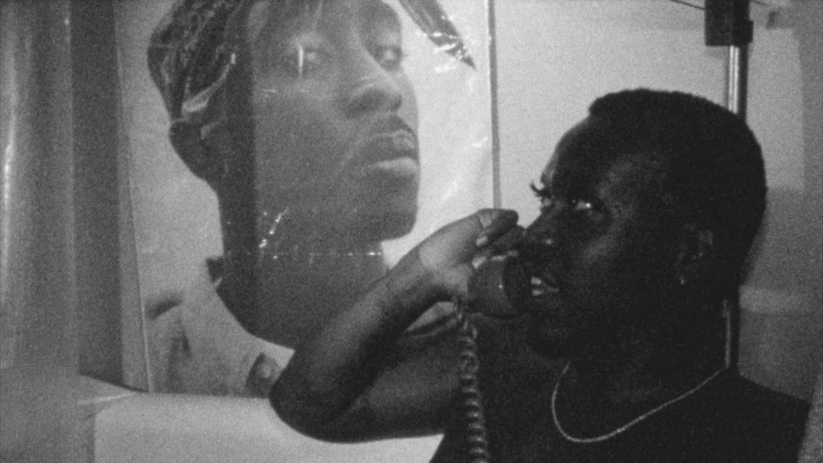 Brontez Purnell, black and white image of young black man in the bathtub on the telephone with an image behind him of Tupac Shakur